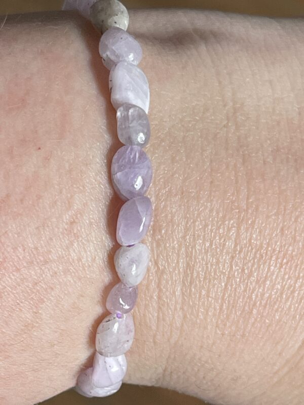 Bracelet en kunzite naturelle porté au poignet – perles lisses et douces teintes lavande.