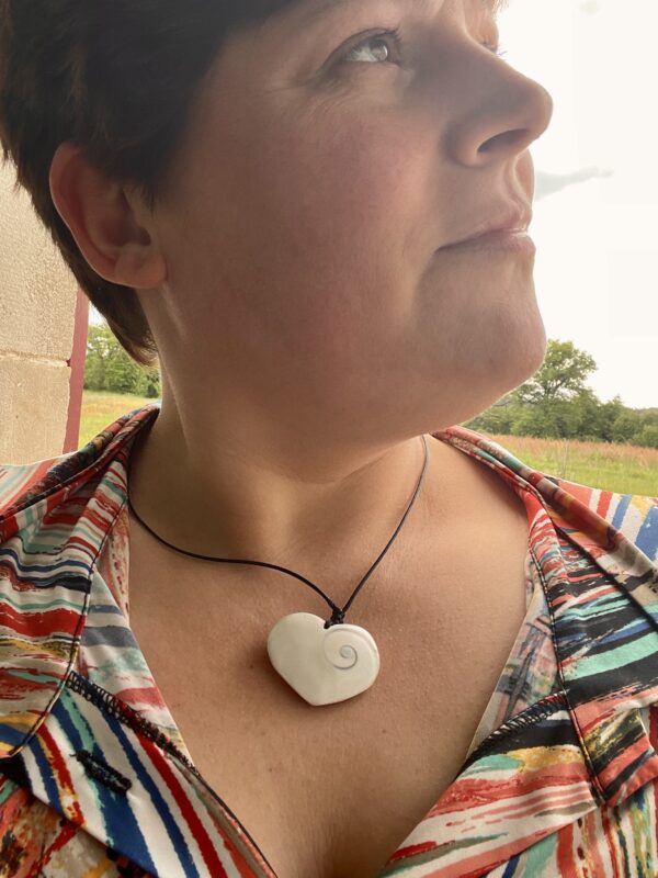 Femme portant un pendentif cœur en œil de Shiva autour du cou